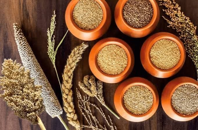 A selection of millet grains arranged in traditional bowls